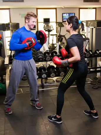 Fitness trainer Scott Laidler leading a boxing workout with client in a London Gym