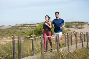 a couple running together on a sandy trail